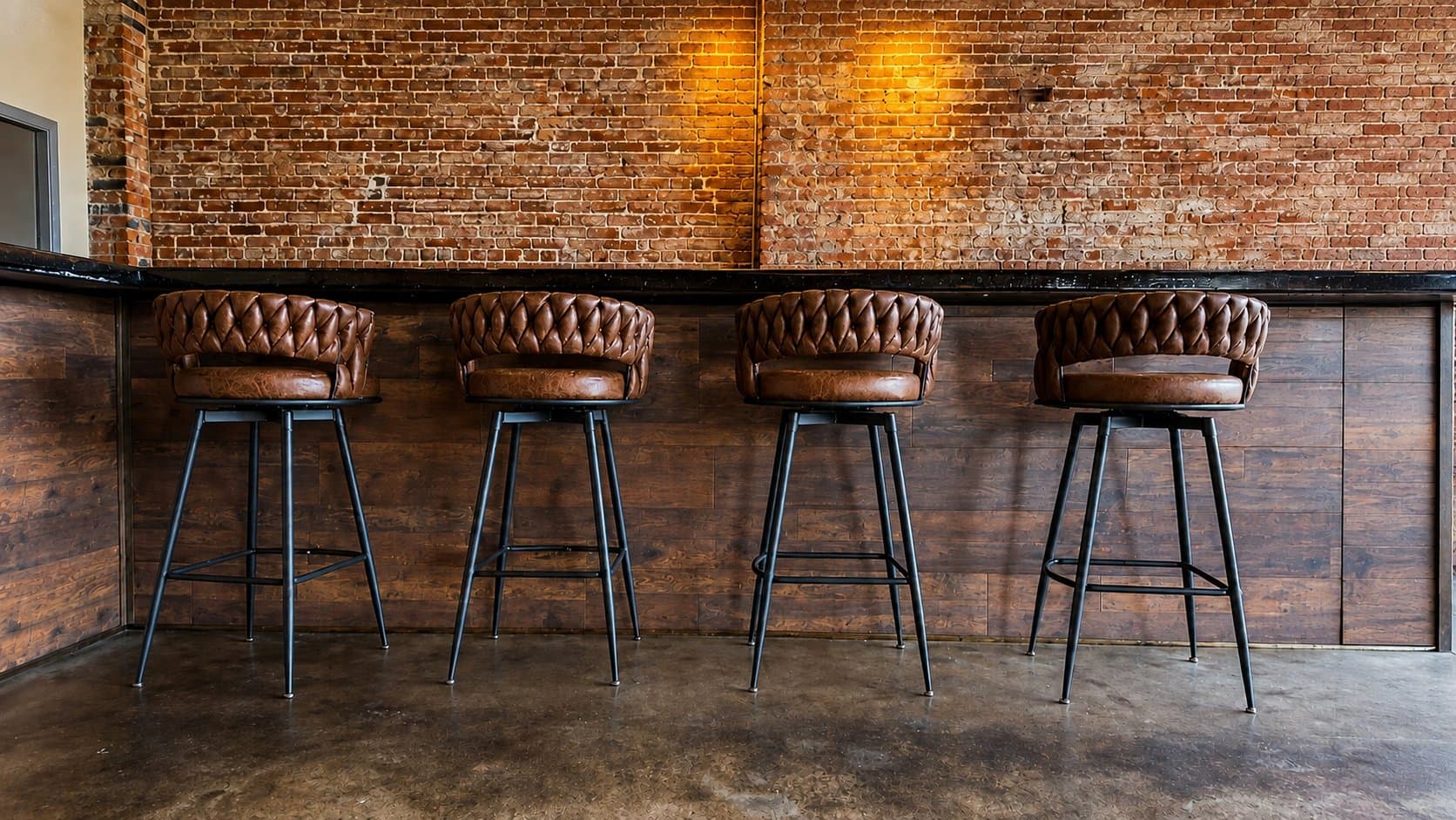 Leather bar stools along the exposed-brick bar