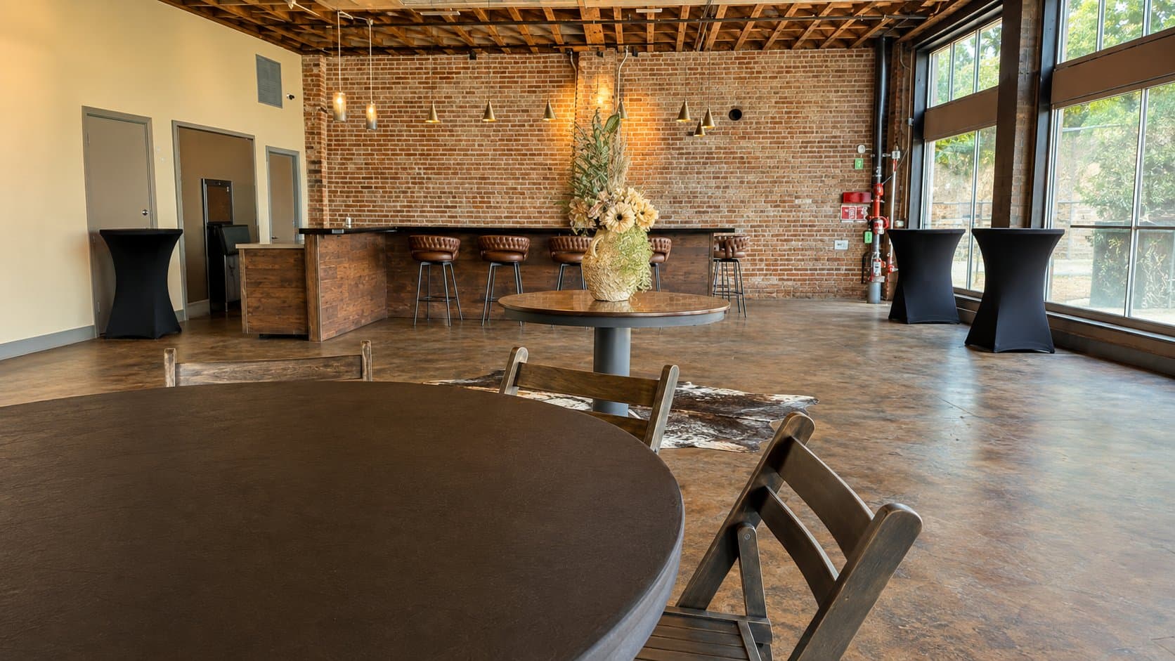 Open bar and lounge area with cocktail tables and a cowhide rug
